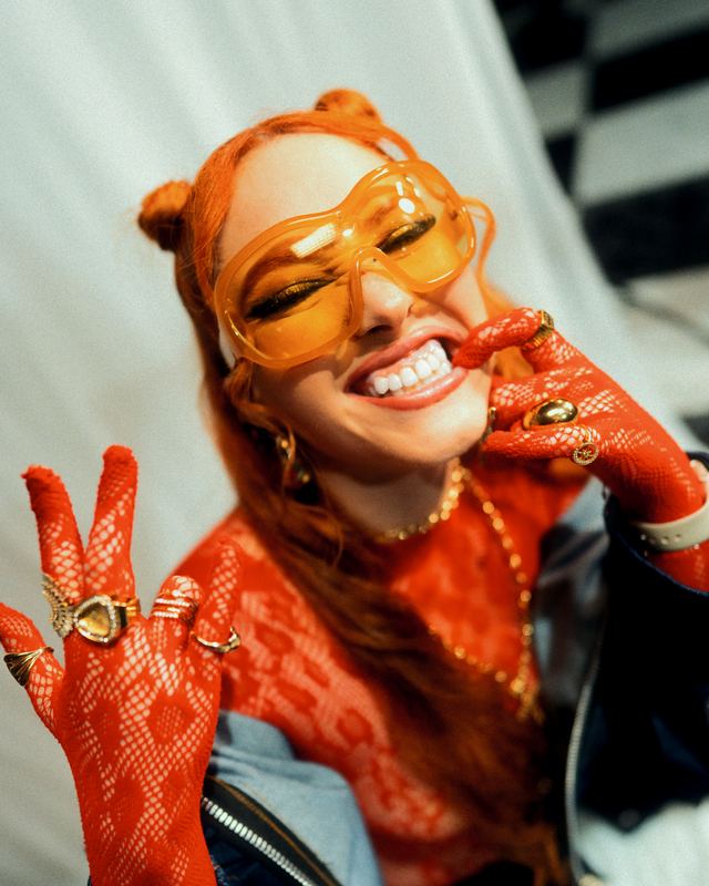 NARA sonriendo con lentes amarillos y guantes rojos